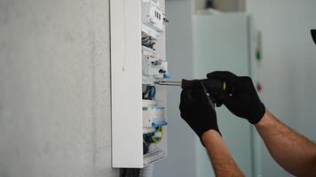 Technical electrician fixing the cable into the terminal of a circuit breaker of a electrical panel video