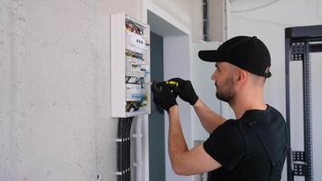 Technical electrician fixing the cable into the terminal of a circuit breaker of a electrical panel video