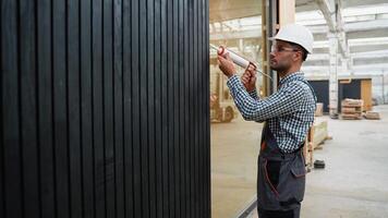 Worker using of foam when installing windows in prefabricated house video