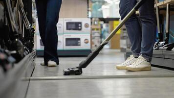 A man trying out vacuum cleaner in tech store. New technologies concept video