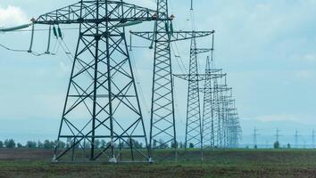 High voltage towers with sky background. Power line support with wires for electricity transmission. High voltage grid tower with wire cable at distribution station. Energy industry, energy saving photo