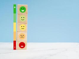 Customer experience, satisfaction, feedback, and services rating concept. Wooden cubes with sad and happy mood icons photo