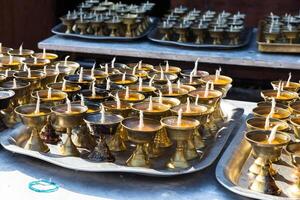 Candles lined up in a row in monastery in Nepal photo