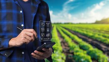 Man holding tablet in field with farm photo