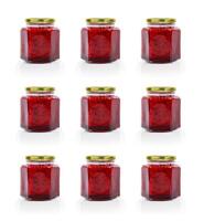 Grid of nine hexagonal glass jars of homemade red currant berry or cranberry jam sealed with a gold colored metal lids. Copy space. Isolated on white background. photo