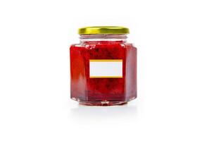 Hexagonal glass jar of homemade red currant berry or cranberry jam with a gold lid and blank label. Isaolated on white background. Copy space. photo