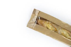 Freshly baked French baguette in a brown paper bag isolated on a white background.Loaf of white bread wrapped in eco-friendly sustainable brown paper bag. Copy space. With clipping path. photo