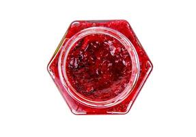 Top view of fresh, vibrant red currant berry jam in an open glass jar, perfect for breakfast spreads or desserts. Closeup. Copy space. Isolated on white background. photo