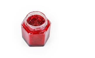 Top view of fresh, vibrant red currant berry jam in an open glass jar, perfect for breakfast spreads or desserts. Closeup. Copy space. Isolated on white background. photo
