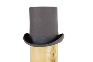 Elegant classic gray top hat with a flat crown and wide brim in the wooden hat block. Topper headpiece Isolated on white background. Copy space. Clipping path photo