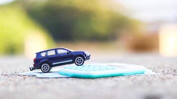 Model car and calculator are on notebook with blur background. Planning of saving for buying car, car loan and car insurance concept. photo