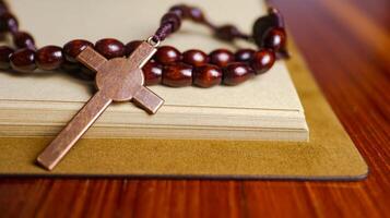 Shiny copper cross leaning against an old open book symbolizing the spread of Jesus Christs love among Christians reflecting faith devotion and the importance of Christian teachings. photo
