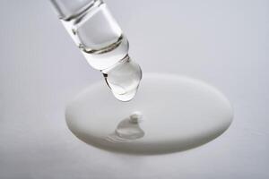 Dropper pipette with delicious serum with drop close-up. photo