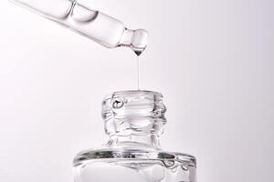 Close-up of a cosmetic bottle with a pipette showing the texture of the serum. photo
