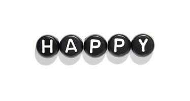 Black stones with white letters forming the word happy on white background with shadows photo