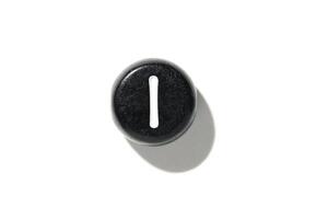 Close-up of black keyboard key with white vertical line on simple white background photo