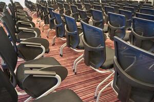 Rows of empty conference chairs on patterned carpet in modern meeting room. photo