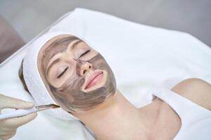 Rejuvenating facial treatment with clay mask at spa for relaxation and skincare. photo