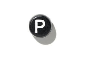 Black button with white letter p isolated on white background with shadow creating bold contrast and minimalist design photo