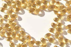 Golden vitamin d capsules forming a circular pattern on a bright surface with shadow effects photo