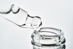 Close-up of a cosmetic bottle with a pipette showing the texture of the serum. photo