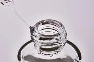 Close-up of a cosmetic bottle with a pipette showing the texture of the serum. photo