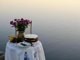 A table with a cake and flowers on it photo