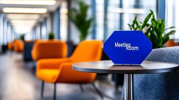 Meeting Room sign on office glass wall with empty collaboration workspace, large table, and armchairs in background. photo