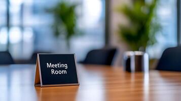 Meeting Room sign on office glass wall with empty collaboration workspace, large table, and armchairs in background. photo
