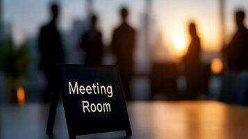 Meeting Room sign on office glass wall with empty collaboration workspace, large table, and armchairs in background. photo