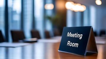 Meeting Room sign on office glass wall with empty collaboration workspace, large table, and armchairs in background. photo