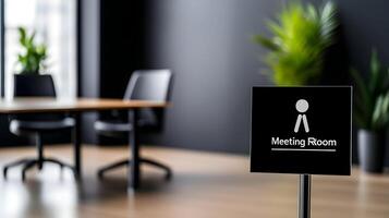 Meeting Room sign on office glass wall with empty collaboration workspace, large table, and armchairs in background. photo