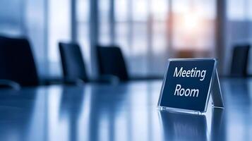 Meeting Room sign on office glass wall with empty collaboration workspace, large table, and armchairs in background. photo