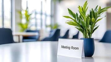 Meeting Room sign on office glass wall with empty collaboration workspace, large table, and armchairs in background. photo