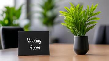 Meeting Room sign on office glass wall with empty collaboration workspace, large table, and armchairs in background. photo