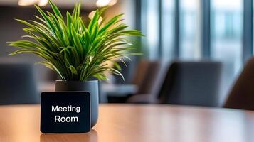 Meeting Room sign on office glass wall with empty collaboration workspace, large table, and armchairs in background. photo