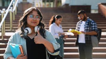 Happy university Indian student going on a class at the university and looking at camera video