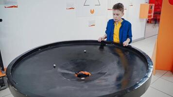 Boy in the museum science. A planet swallowed by black hole simulation, endless gravity video