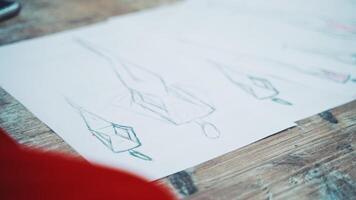 White sheets of papers with stylish sketches painted on the table. A lot of creative works of a fashionable designer and red material for seamstress in atelier. video