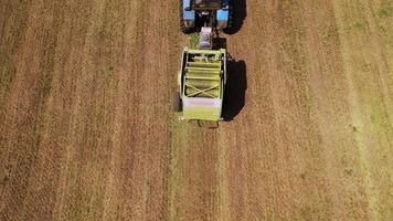Working process of agricultural tractor outdoors in summer. Top view of special pressing machine on the field background. video