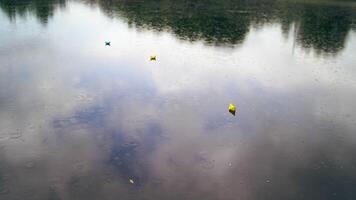 Three colorful paper ships on water under the rain. Handmade origami ships are floating on the water surface during the rain outdoors. Top view. video