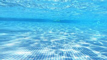 Empty swimming pool underwater with surface ripples. Bottom of the pool on the background of blue clear water inside. video