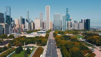 Cityscape of Downtown Skyline with Green Urban Park. An aerial view of a cityscape featuring a dense skyline of skyscrapers and a wide urban park with trees displaying autumn colors. video