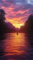 Solitary Kayaker at Sunset with Mountain Silhouette and Rippling Water photo