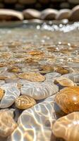 Smooth River Rocks Submerged in Clear Water with Light Reflecting photo