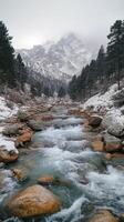 A Snow-Capped Mountain Range Surrounding a Rushing River photo