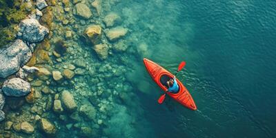 Aerial View of a Single Kayaker Paddling Through a Rocky Inlet photo
