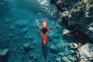 Aerial View of a Kayaker Paddling in a Pristine Blue Lake Surrounded by Rocky Shores photo