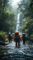 Hikers Walking Through a River and Waterfall in a Lush Forest photo