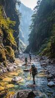 Hikers Traverse a Rocky Stream in a Narrow Mountain Gorge photo